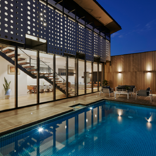 A clean swimming pool with blue water at a modern house.